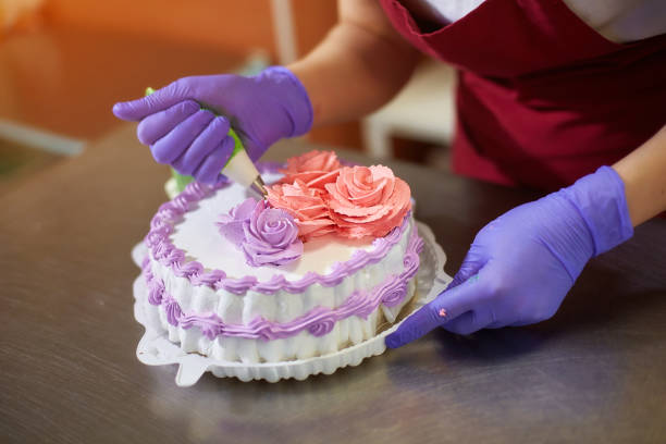 pastry-chef-decorates-the-cake-with-flowers-from-the-cream-the-cream-picture-id1252881919